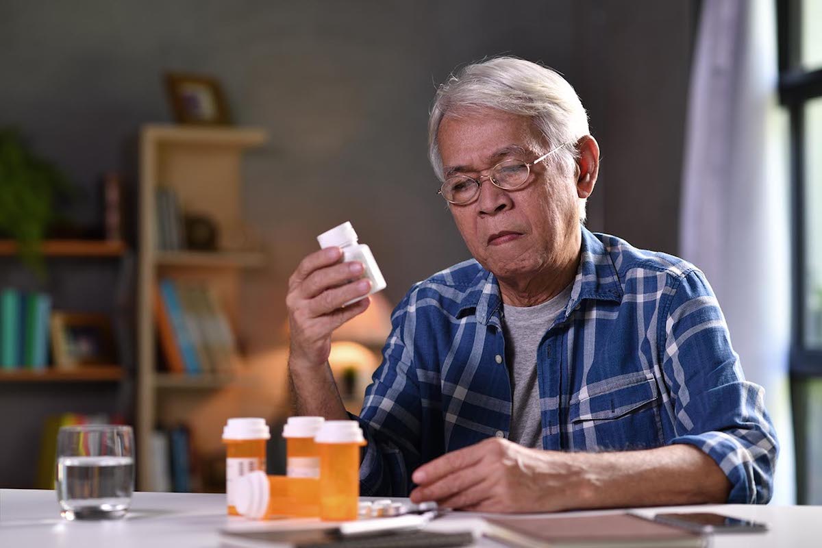 Asian Senior Man With His Medicine Bottles