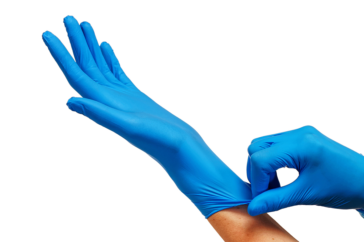 Doctor Putting On Protective Blue Gloves Isolated On White