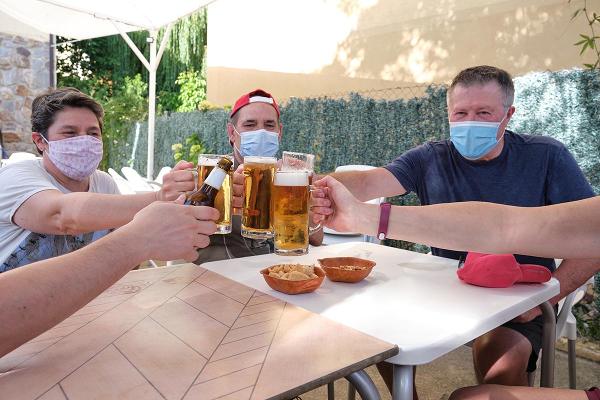 People With Face Masks Cheering With Beers In A Bar