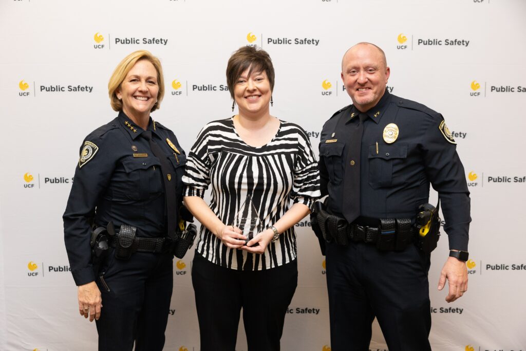 Jennifer Floyd standing with Associate Vice President of Public Safety and Chief of Police Robin Griffin-Kitzerow and Deputy Chief of Police Scott Freeman during the UCF Public Safety Awards ceremony. 