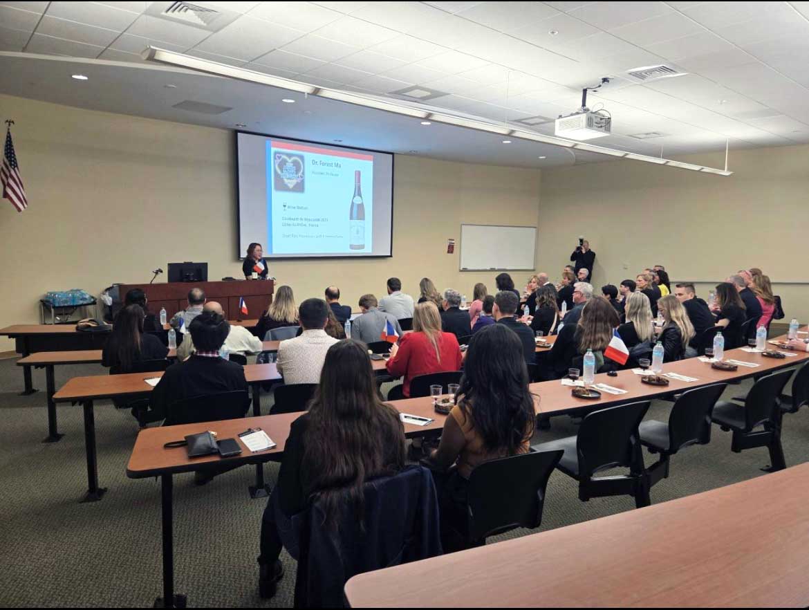 Dr. Forest Ma speaks from a podium during a wine tasting for a classroom of attendees at UCF Alumni’s Date Knight 2026.