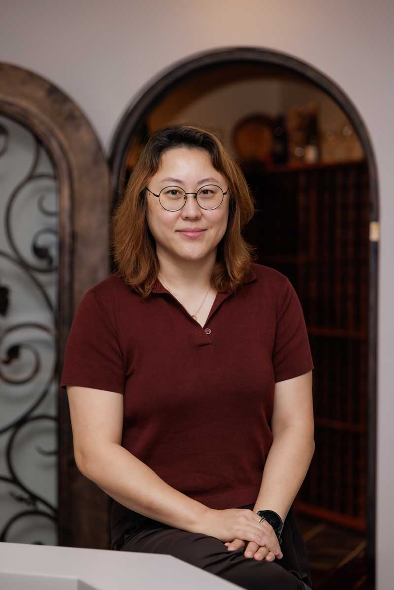 Dr. Forest Ma in maroon polo shirt, poses for a picture in front of a door and entrance to the Rosen College Beer and Wine Lab.
